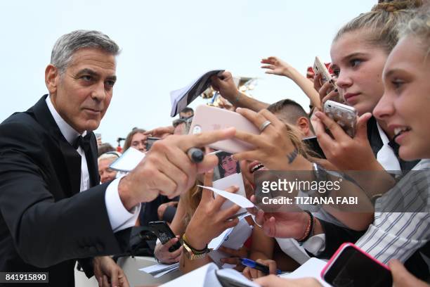 Actor and director George Clooney signs autographs before the premiere of the movie "Suburbicon" presented out of competition at the 74th Venice Film...