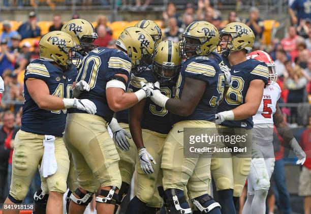 Qadree Ollison of the Pittsburgh Panthers celebrates with teammates after rushing for a touchdown in the first quarter during the game against the...