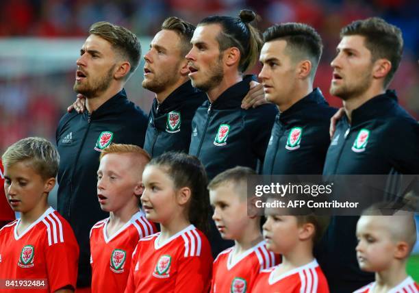 Wales' striker Gareth Bale and teammates sing the national anthem before the FIFA World Cup 2018 qualification international football match between...