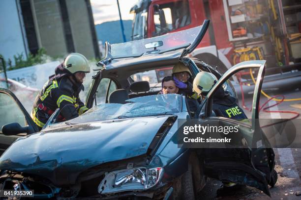 bomberos rescatando heridos hombre "n - carro de bombeiro fotografías e imágenes de stock