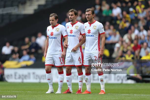 Peter Pawlett, Ed Upson and Alex Gilbey of Milton Keynes Dons line up to defend a free kick during the Sky Bet League One match between Milton Keynes...