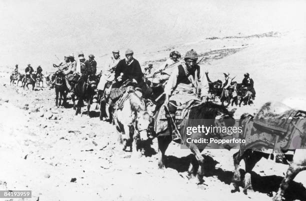 The 14th Dalai Lama flees from Tibet to India across the Himalayas, following a failed uprising against the Chinese occupation, 1959. He is riding a...