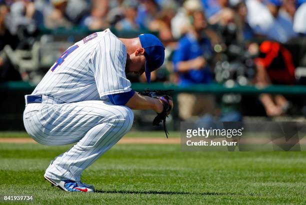 Jon Lester of the Chicago Cubs reacts after giving up a single to Matt Kemp of the Atlanta Braves to load the bases during the first inning at...