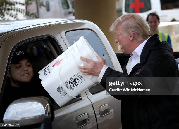 President Donald Trump hands out emergency supplies to residents impacted by Hurricane Harvey while visiting the First Church of Pearland September...