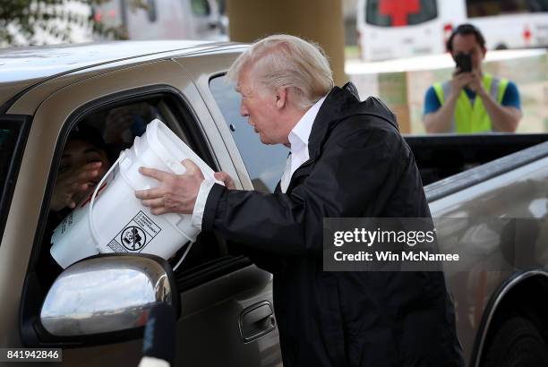 President Donald Trump hands out emergency supplies to residents impacted by Hurricane Harvey while visiting the First Church of Pearland September...