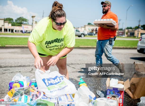 Volunteers help load Harvey victims cars with donated supplies outside Center Mall in Port Arthur, Texas, on September 2, 2017. As floodwaters...