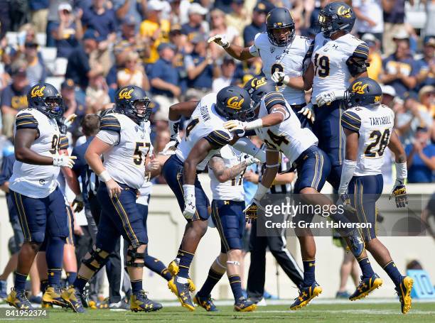 Derron Brown of the California Golden Bears celebrates sith teammates after intercepting a pass against the North Carolina Tar Heels during their...
