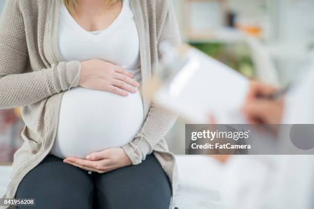 trattenere lo stomaco - obstetrician foto e immagini stock