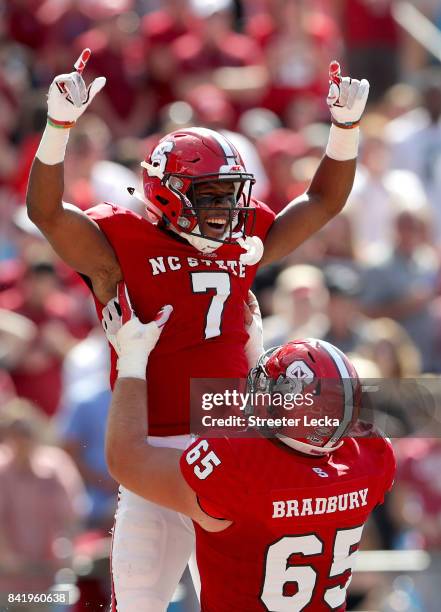 Nyheim Hines and teammate Garrett Bradbury of the North Carolina State Wolfpack celebrate after Hines scores a touchdown against the South Carolina...