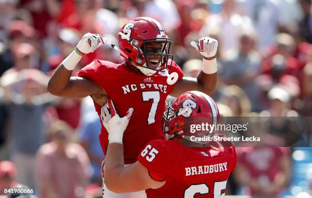 Nyheim Hines and teammate Garrett Bradbury of the North Carolina State Wolfpack celebrate after Hines scores a touchdown against the South Carolina...