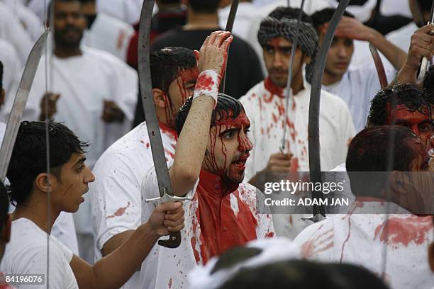 Bahraini Shiite Muslims perform a religious mourning ritual during which they cut their scalps with swords to mark the final day of Ashura in a...