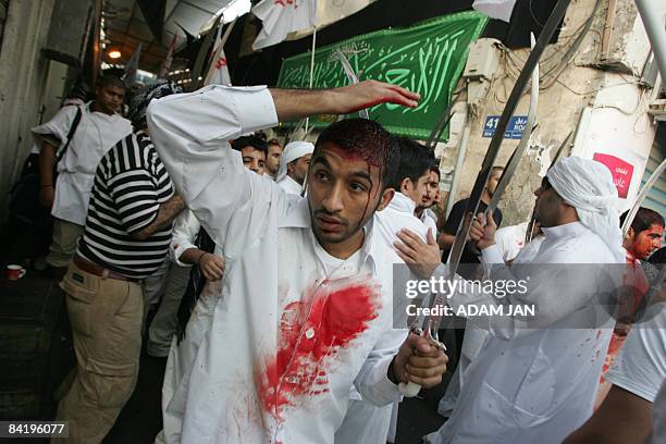 Bahraini Shiite Muslims perform a religious mourning ritual during which they cut their scalps with swords to mark the final day of Ashura in a...