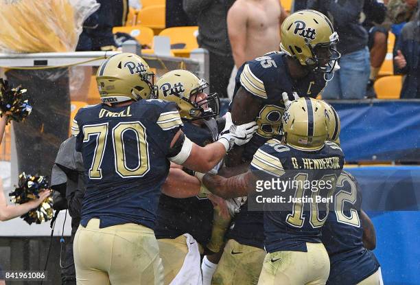 Jester Weah of the Pittsburgh Panthers celebrates with teammates after a 11 yard touchdown reception in overtime during the game against the...