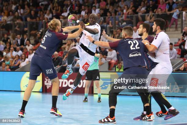 Olivier Nyokas of HBC Nantes is trying to shoot the ball against Henrik Mollgaard and Luka Karabatic of Paris Saint Germain during the Final of the...