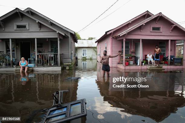 Residents hang out in front of their homes which are surrounded by floodwater after torrential rains pounded Southeast Texas following Hurricane and...