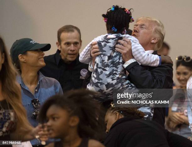 President Donald Trump and First Lady Melania Trump greet a young Hurricane Harvey victim at NRG Center in Houston on September 2, 2017. / AFP PHOTO...