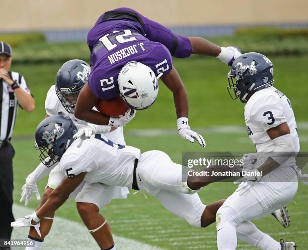 Justin Jackson of the Northwestern Wildcats flips in the air after being hit by Dameon Baber of the Nevada Wolf Pack at Ryan Field on September 2,...