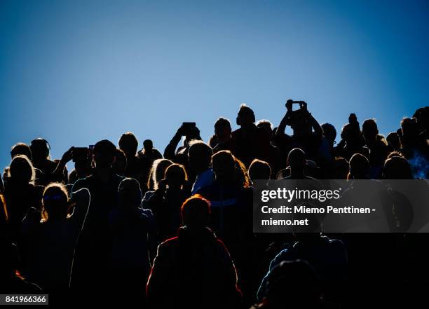 backlit crowd spectating an outdoors event under a clear blue sky - crowd in silhouette stock pictures, royalty-free photos & images