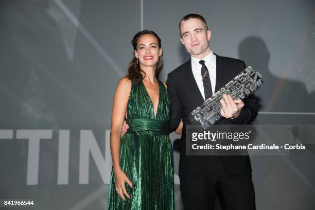 Actor Robert Pattinson receives an achievement tribute award by French actress Berenice Bejo during the 43rd Deauville American Film Festival on...