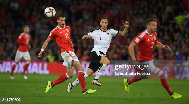 Austria player Marko Arnautovic gets in a shot despite the attentions of Gareth Bale and Chris Gunter during the FIFA 2018 World Cup Qualifier...