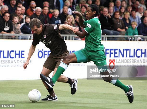 Carsten Rothenbach of St. Pauli tackles Caiuby of Wolfsburg during the Indoor Football Cup match between FC St. Pauli and VFL Wolfsburg at the Weser...