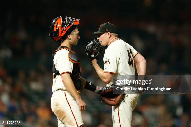 Catcher Buster Posey of the San Francisco Giants talked to pitcher Mark Melancon of the San Francisco Giants during the eighth inning against the St...