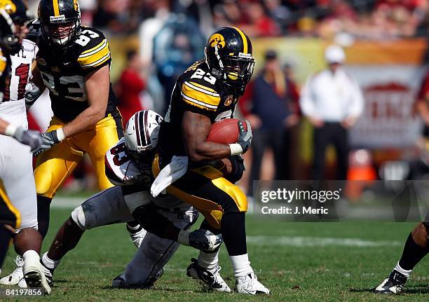 Running back Shonn Greene of the Iowa Hawkeyes attempts to break the tackle of defensive end Cliff Matthews of the South Carolina Gamecocks during...