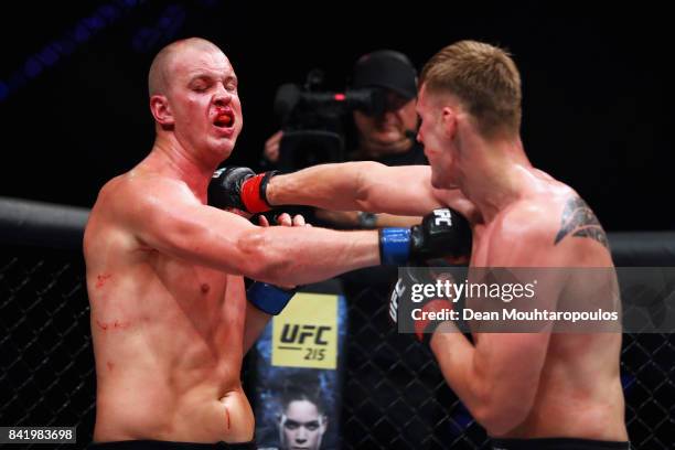 Alexander Volkov of Russia hits Stefan Struve of the Netherlands as they compete in their Heavyweight bout during the UFC Fight Night at Ahoy on...