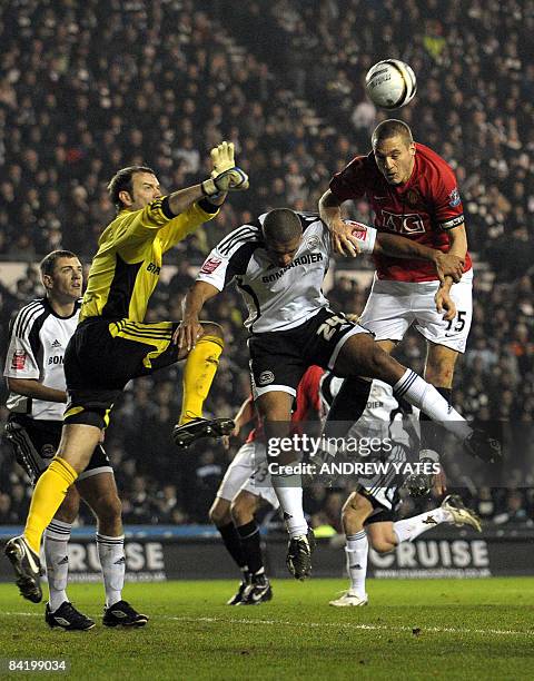 Manchester United's Serbian defender Nemanja Vidic vies in the air with Derby County's English defender Miles Addison and Derby County's Irish...