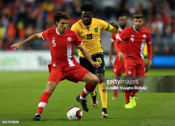 Dejan Jakovic of Canada battles for the ball with Ricardo Morris of Jamaica during the first half of an International Friendly match at BMO Field on...