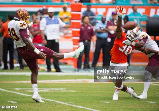 Bethune-Cookman Wildcats Kicker Javaunie Francis punts the ball past University of Miami Hurricanes Defensive Back Romeo Finley during the college...