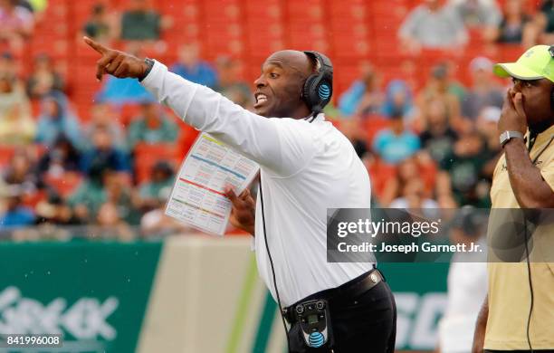 Head coach Charlie Strong of the South Florida Bulls yells instructions to his team on the field during the game against the Stony Brook Sea Wolves...