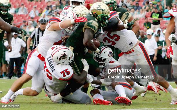 Running back Darius Tice fights for yardage against the Stony Brook Sea Wolves' defenders at Raymond James Stadium on September 2, 2017 in Tampa,...