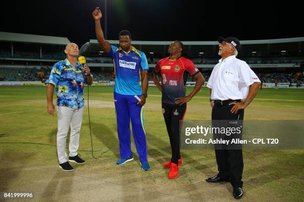 In this handout image provided by CPL T20, Kieron Pollard captain of Barbados Tridents flips the coin as Dwayne Bravo captain of the Trinbago Knight...