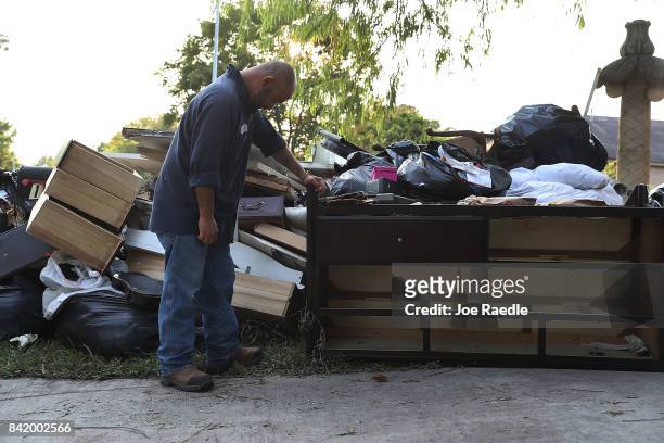Ernesto Ramirez pauses as he cleans out his house that had been inundated with water after torrential rains caused widespread flooding during...