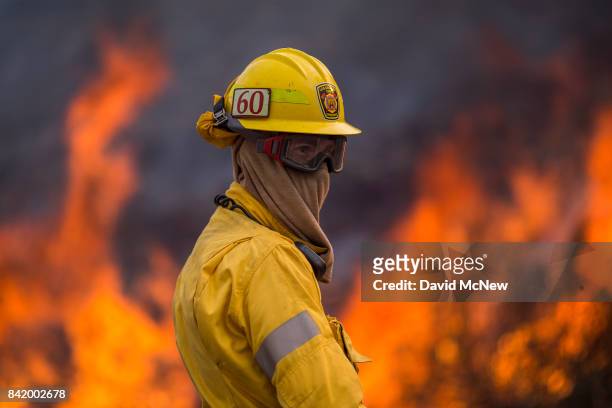 Flames rise behind a firefighter at the La Tuna Fire on September 2, 2017 near Burbank, California. Los Angeles Mayor Eric Garcetti said at a news...