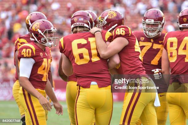 Jake Olson, who is blind, gets congratulated by his teammates after snapping the ball for an extra point for the first time in a NCAA Football game...
