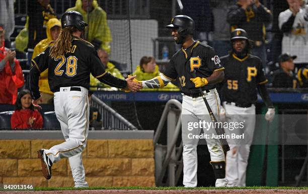 John Jaso of the Pittsburgh Pirates is greeted by Andrew McCutchen after coming around to score on an RBI single by Starling Marte in the seventh...