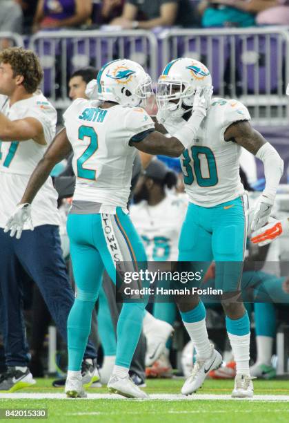 Maurice Smith and Cordrea Tankersley of the Miami Dolphins celebrate an incomplete pass against the Minnesota Vikings in the preseason game on August...