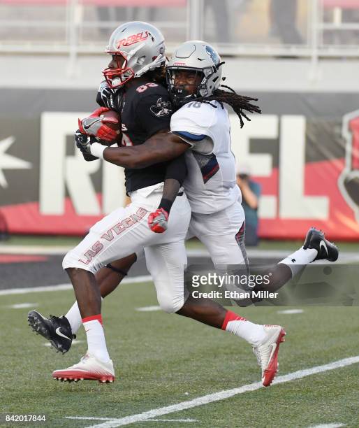 Wide receiver Devonte Boyd of the UNLV Rebels catches a pass for a 46-yard gain against Travon Hunt of the Howard Bison during their game at Sam Boyd...