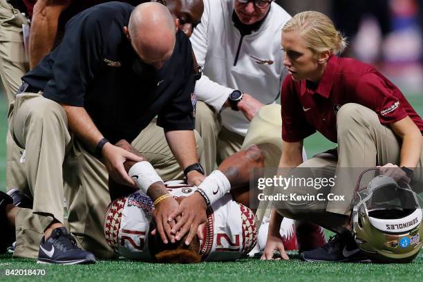 Deondre Francois of the Florida State Seminoles is attended to by medical personnel after being injured in the fourth quarter of their game against...