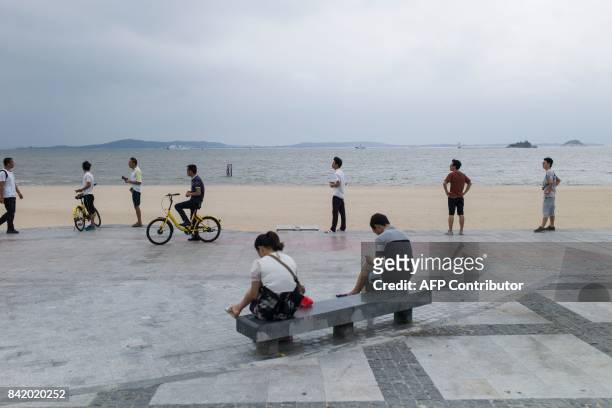 Chinese plainclothes police stand by the shore next to the media centre for the BRICS Summit in Xiamen, Fujian province on September 3, 2017. The...