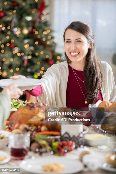 cheerful christmas dinner guest passes empty plate - christmas party host stock pictures, royalty-free photos & images