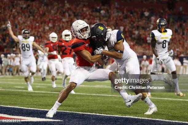 Running back Cory Young of the Northern Arizona Lumberjacks scores on a seven yard rushing touchdown against cornerback Lorenzo Burns of the Arizona...