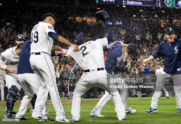 Edwin Diaz of the Seattle Mariners, left throws water on Jean Segura, who scored the winning run on a wild pitch by Blake Treinen of the Oakland...