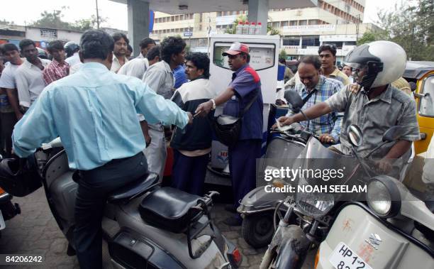 Indian motorcyclists wait in line to buy petrol in short supply, due to a nationwide truckers' strike, at a gas station in Hyderabad on January 8,...