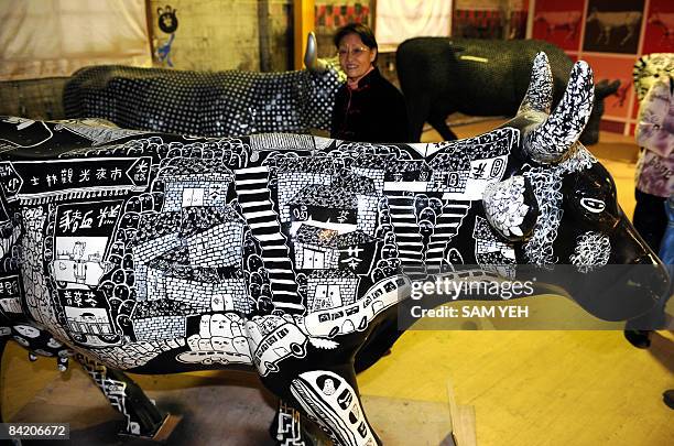 Woman admires an Ox-shaped statue decorated with colorful crystal and flowers during the Cow Parade exhibition in Taipei on January 8, 2009. More...