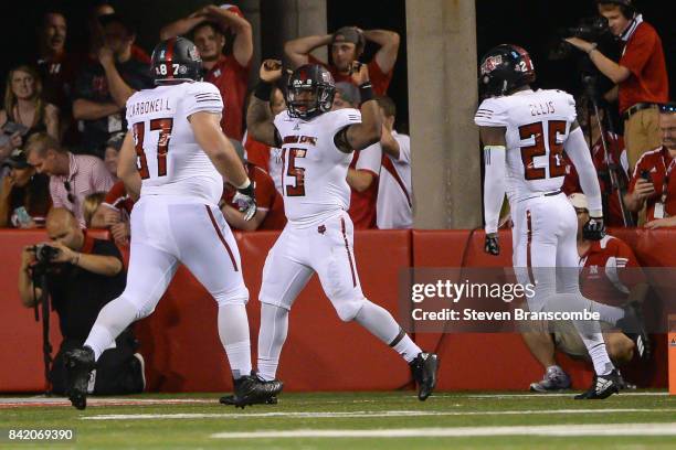 Linebacker Kyle Wilson of the Arkansas State Red Wolves celebrates with defensive lineman Javier Carbonell and linebacker Trent Ellis after a safety...