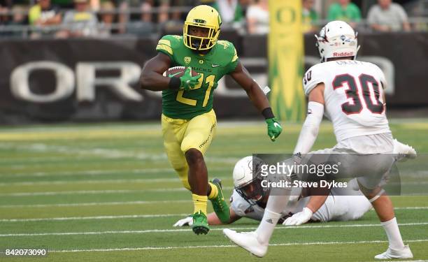 Running back Royce Freeman of the Oregon Ducks runs the ball as safety Tyler Collet of the Southern Utah Thunderbirds defends in the first quarter of...