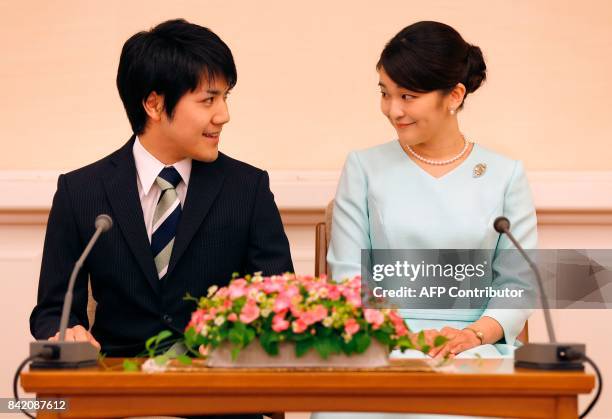 Princess Mako , the eldest daughter of Prince Akishino and Princess Kiko, and her fiancee Kei Komuro , smile during a press conference to announce...